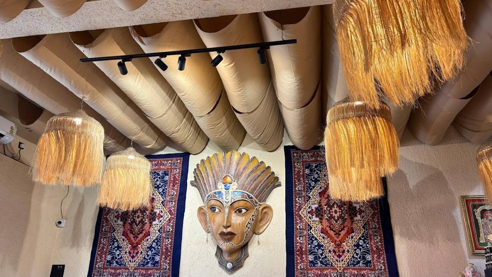 Mask, rugs and raffia lamps inside the café