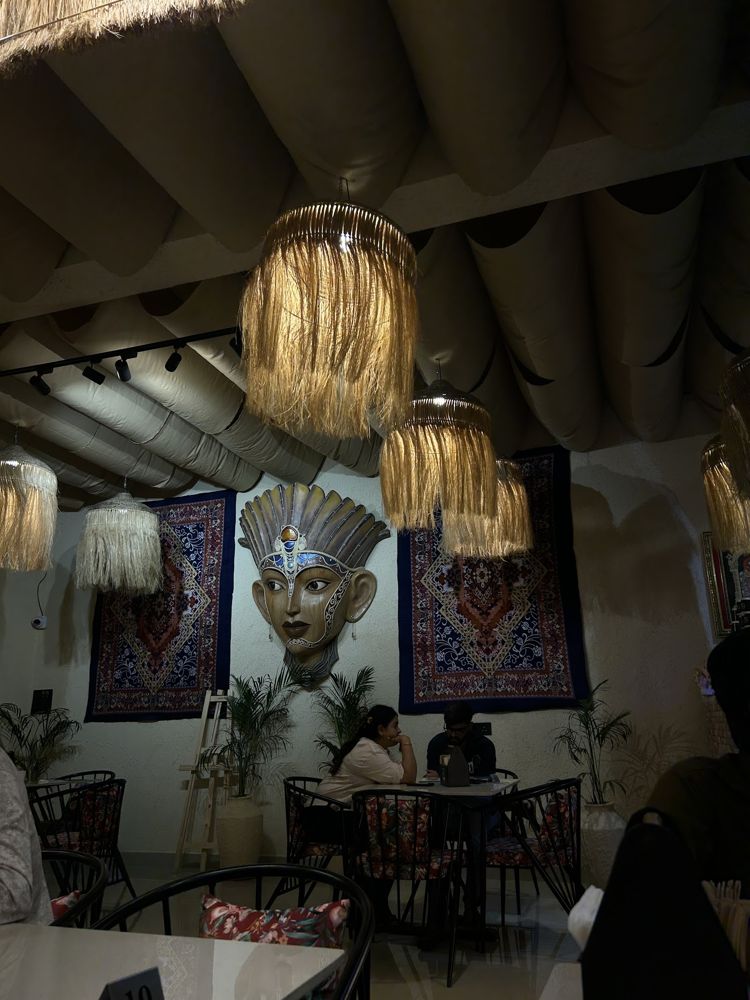 Seating under raffia lamps with the mask and rugs