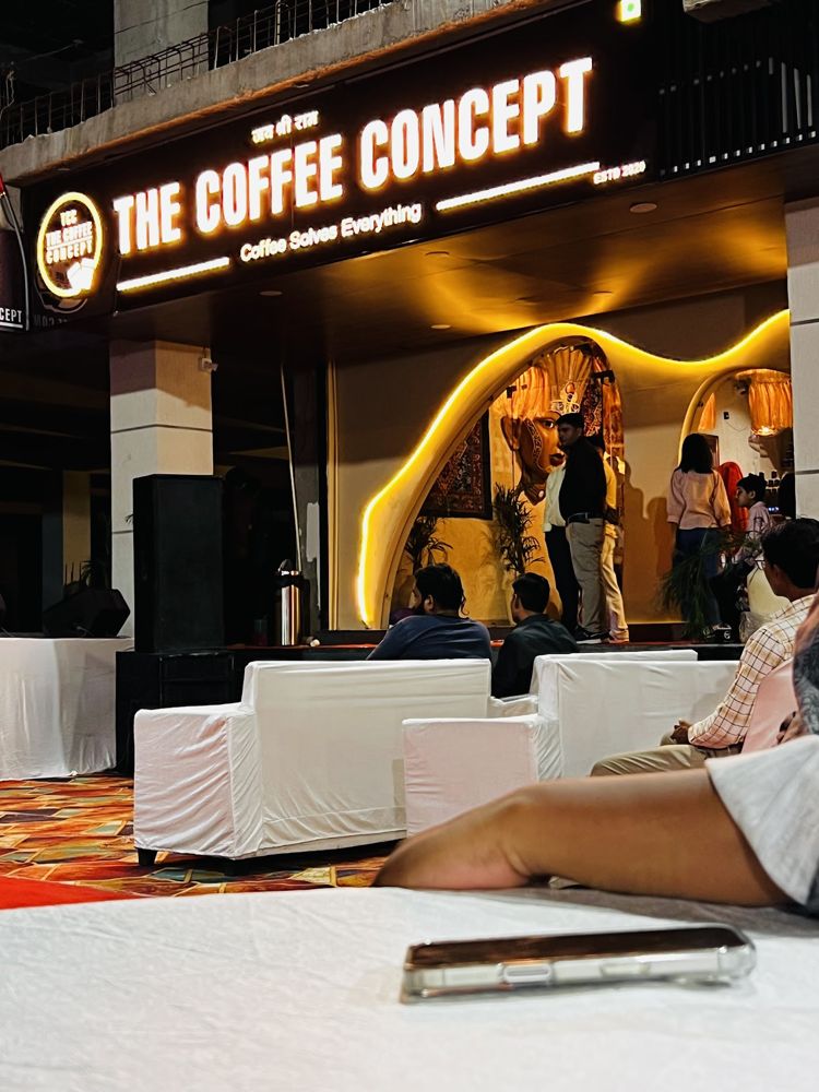The Coffee Concept storefront lit up at night